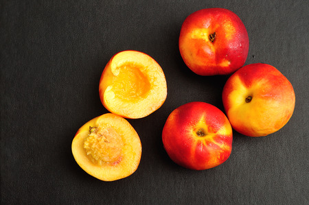 Whole nectarines with only one cut in halfの写真素材