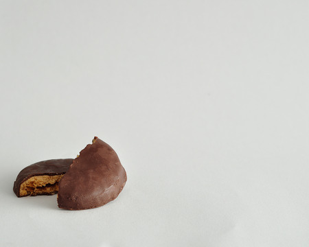 A round biscuits covered in chocolate broken in halfの写真素材