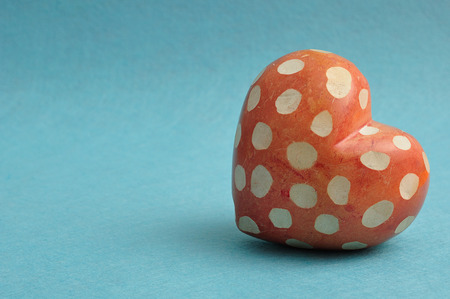 Valentine's day. A spotted red and white heart isolated on a blue background