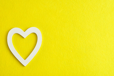 Valentine's Day. A white heart isolated against a yellow background