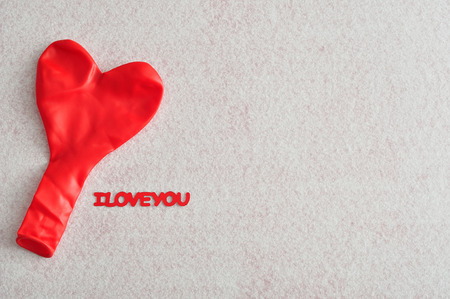 Valentine's Day. A Red heart shape balloon isolated against a white background with I love you in textの写真素材