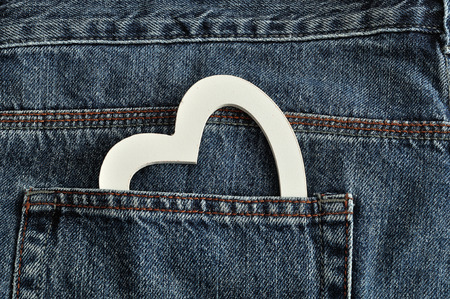 Valentines day. A white heart sticking out of a back pocket of a denim jean