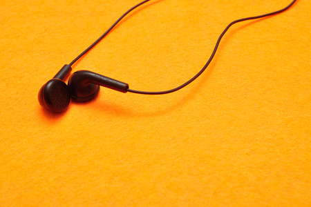 Earphones isolated against a yellow background