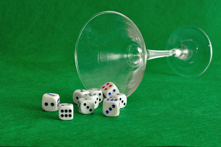 Various sizes of dice falling out of a martini glassの写真素材