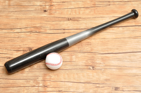 A baseball bat and ball isolated on a wooden backgroundの写真素材