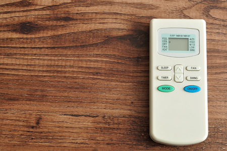 An air conditioners remote isolated on a wooden backgroundの写真素材