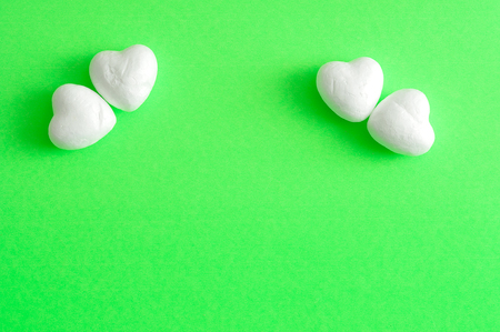 Valentine's Day. White polystyrene hearts on a green backgroundの写真素材