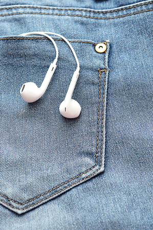 White earphones in the back pocket of a denimの写真素材