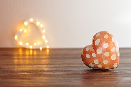 A red and white spotted heart with an out of focus light heart shapeの写真素材