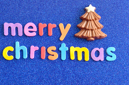 A chocolate Christmas tree with the words Merry Christmas on a blue backgroundの写真素材