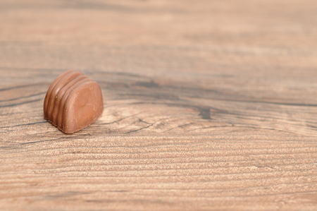 A single chocolate displayed on a wooden backgroundの写真素材