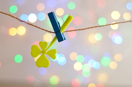 A clover hanging on line with an out of focus light backgroundの写真素材