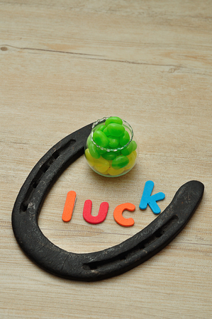 The word luck with a horse shoe and a pot with yellow and green jellybeansの写真素材