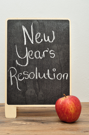 A black board with the words new years resolution and an appleの写真素材