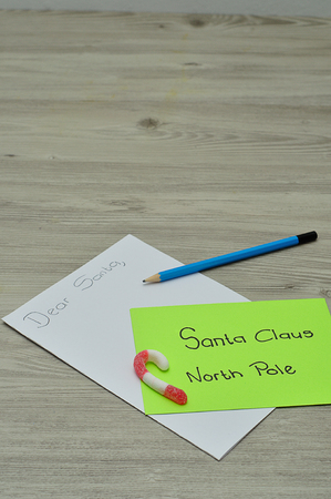 A letter to Santa Claus at the North Pole with a candy cane and a pencilの写真素材