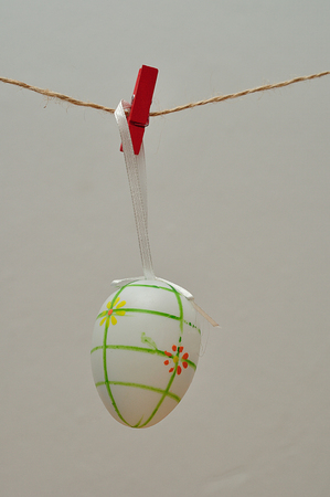 A colorful easter egg decoration hanging on a stringの写真素材