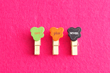 Two plus seven on a pink backgroundの写真素材