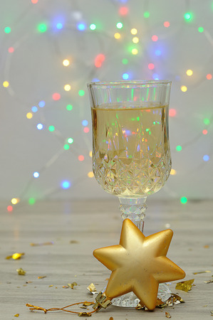 A glass of champagne displayed with a gold star shape christmas tree decorationの写真素材