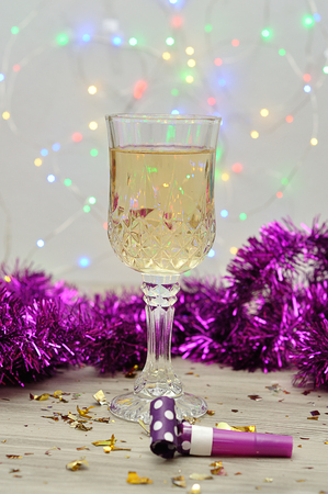 A glass of champagne displayed with purple tinselの写真素材