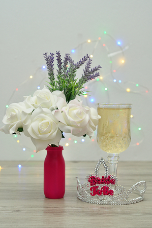 A tiara with the words bride to be displayed with a glass of champagne and a bouquet of roses and lavenderの写真素材