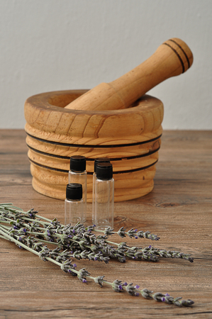 A bunch of lavender displayed with a wooden pestle and a small empty bottlesの写真素材