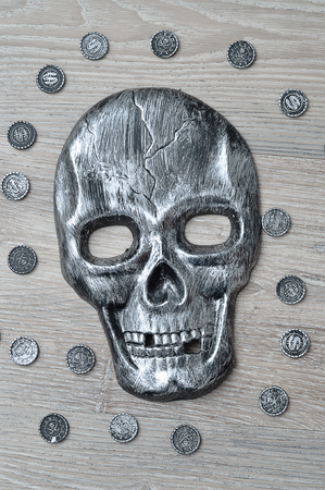 A skull mask with toy pirate coinsの写真素材