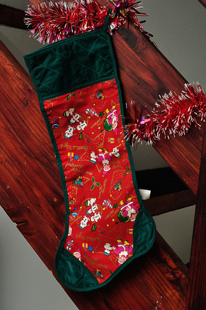 A christmas stocking hanging on the side of wooden stairsの写真素材