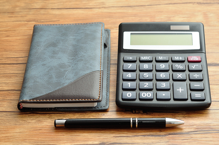 A calculator displayed with a notebook and a penの写真素材