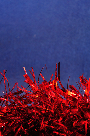 Red tinsel against a blue backgroundの写真素材