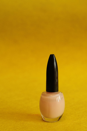 Pink nail polish against a yellow backgroundの写真素材