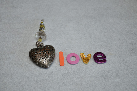The word love with a decorated steel heart on a white backgroundの写真素材
