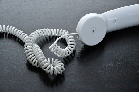 A handset of a phone lying on a table with shallow depth of fieldの写真素材