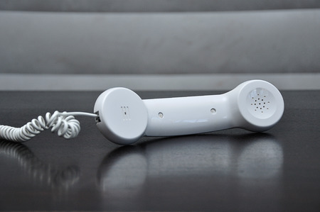 A handset of a phone lying on a table with shallow depth of fieldの写真素材