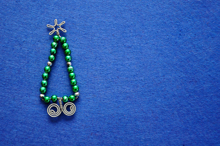 A christmas tree made out of beads and wire on a blue backgroundの写真素材