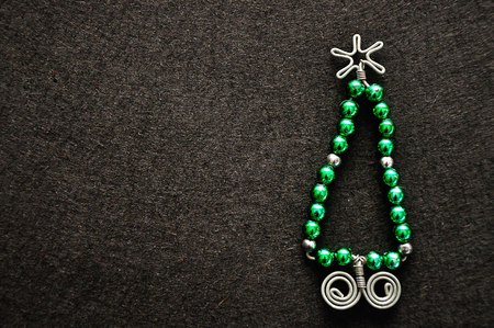 A christmas tree made out of beads and wire on a black backgroundの写真素材