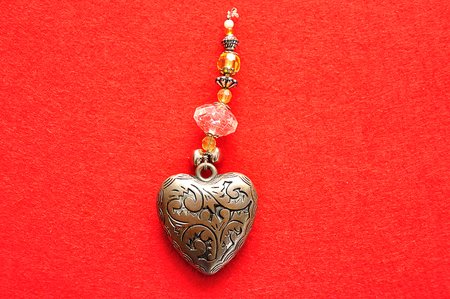 A decorated steel heart on a red backgroundの写真素材