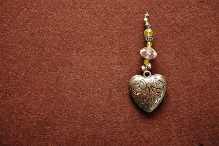 A decorated steel heart on a brown backgroundの写真素材