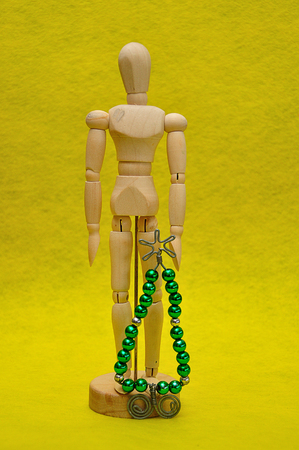 A wooden mannequin display with a christmas tree made out of wire and beadsの写真素材