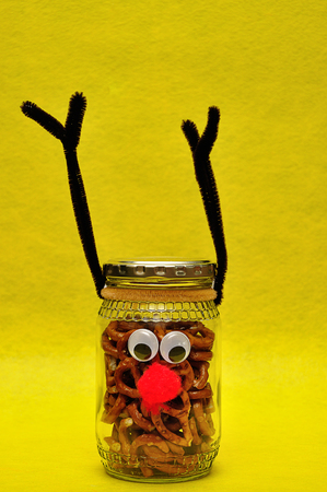 A jar decorated as a reindeer filled with pretzelsの写真素材