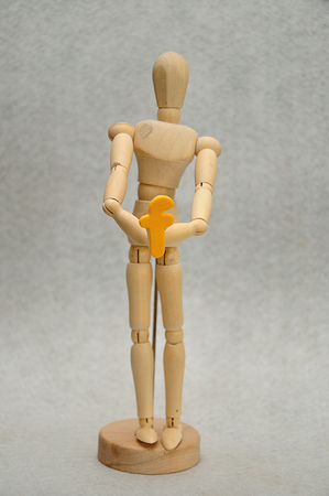 A wooden mannequin holding a letter fの写真素材