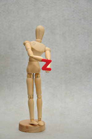 A wooden mannequin holding a letter zの写真素材