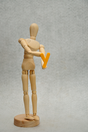 A wooden mannequin holding a letter yの写真素材