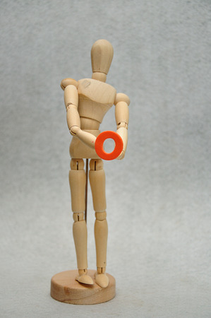 A wooden mannequin holding a letter oの写真素材