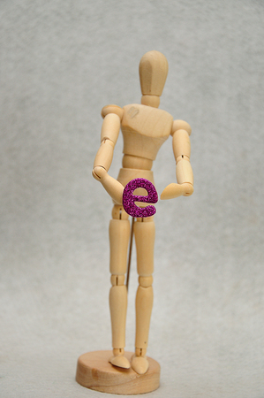 A wooden mannequin holding a letter eの写真素材