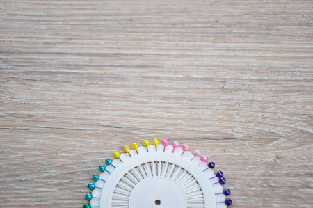 Straight pins in a white container on a wooden backgroundの写真素材