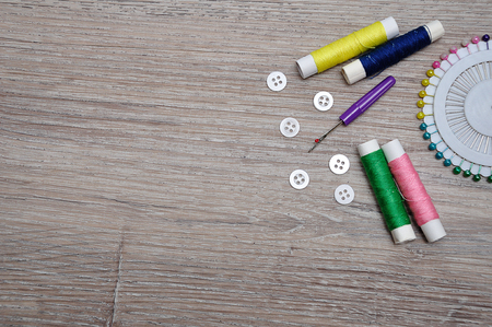 A variety of needle work supplies on a wooden backgroundの写真素材