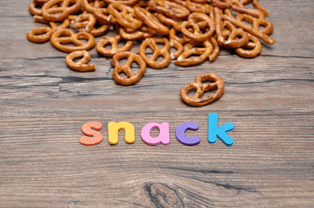 A pile of golden brown pretzels with the word snackの写真素材