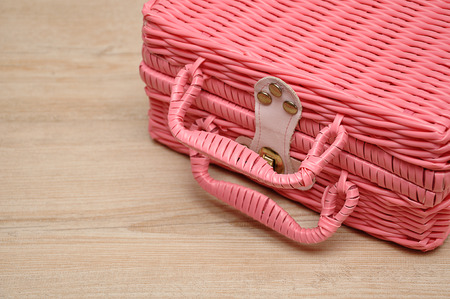 A pink basket on a wooden backgroundの写真素材