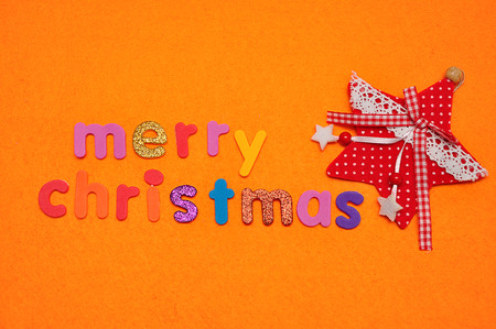 A red star and Merry Christmas on an orange backgroundの写真素材