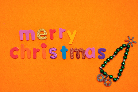 A Bead Christmas tree and Merry Christmas on an orange backgroundの写真素材